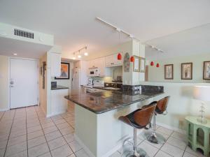 a kitchen with a counter and two bar stools at Relaxing Condo, Great Location, 3 Minute Walk To The Beach Condo in South Padre Island