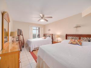 a bedroom with two beds and a ceiling fan at Relaxing Condo, Great Location, 3 Minute Walk To The Beach Condo in South Padre Island