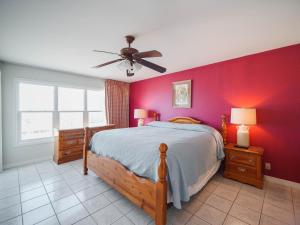 um quarto com uma cama e uma parede vermelha em Relaxing Condo, Great Location, 3 Minute Walk To The Beach Condo em South Padre Island