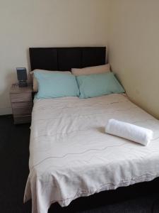 Una cama grande con una almohada encima. en Cosy Homes, en Liverpool