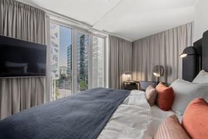 a bedroom with a large bed and a large window at Clarion Hotel Oslo in Oslo