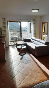 een woonkamer met banken en een tafel en uitzicht bij Apartamento amplio y tranquilo con vistas in Los Realejos