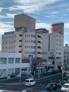 un estacionamiento con autos estacionados frente a un edificio en Matsue Urban Hotel CubicRoom en Matsue