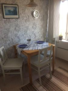 a dining room table with two chairs and a table with blue plates at Annies Hus in Årjäng