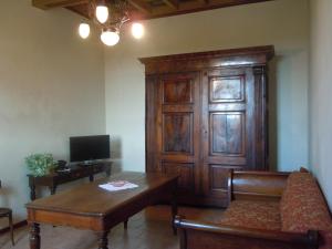 ein Wohnzimmer mit einem Sofa und einem Holzschrank in der Unterkunft Ostello La Canonica in Motta Baluffi