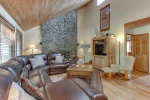 a living room with a leather couch and a stone wall at 10 Yellow Rail in Sunriver
