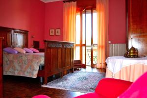 een slaapkamer met 2 bedden en rode muren bij Monvillone in Cereseto