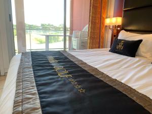 a bed with a black and gold blanket on it at Mer et Golf in Anglet