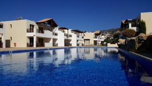 a large swimming pool in front of some buildings at Stunning apartment C106 with balcony looking over pool in Peyia
