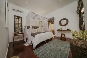 a bedroom with a bed with a canopy at Villa Eight in Seminyak