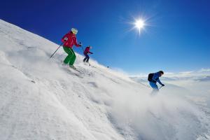 three people skiing down a snow covered slope at Haus Mariandl in Westendorf