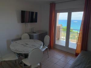 een kamer met een tafel en stoelen en een balkon bij Mer et Golf in Anglet