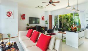 a living room with a white couch with red pillows at Eranda Pool Spa Villa, Chaweng Koh Samui in Chaweng +48 photos