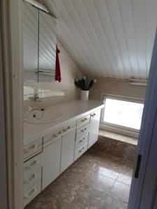 La salle de bains est pourvue d'un lavabo, d'un miroir et d'une fenêtre. dans l'établissement Talvitaival Apartments, à Varkaus