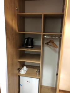 a closet with wooden shelves and a refrigerator at Vila Alexandra in Sarajevo