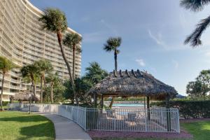 a gazebo and palm trees next to a building at Crystal Waves in Marco Island
