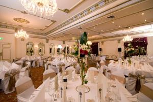 a banquet hall with white tables and white chairs at Palais Royale in Katoomba