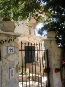 un cancello in ferro battuto di fronte a una casa di Villa Ceni - Appartamenti con camere, cucina, wc e terrazza sul mare in villa con piscina, giardino e parcheggio a Marinella di Selinunte