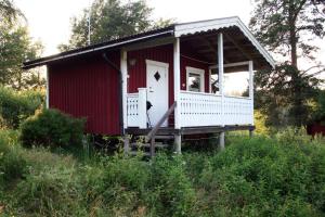 una casa rossa e bianca con portico di Skräddarbo a Årjäng