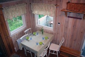 una sala da pranzo con tavolo e sedie e due finestre di Skräddarbo a Årjäng