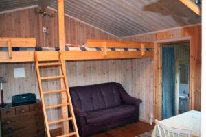 una camera da letto con un letto a castello e un divano di Skräddarbo a Årjäng