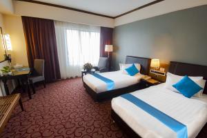 Postel nebo postele na pokoji v ubytování Kinta Riverfront Hotel & Suites