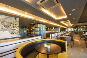 um restaurante com mesas e cadeiras e um bar em Kinta Riverfront Hotel & Suites em Ipoh