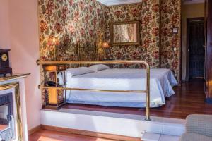 una camera con un letto in una stanza con carta da parati floreale di Hotel Alabardero a Siviglia