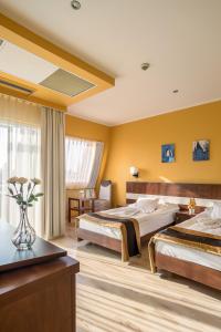 A bed or beds in a room at Holiday Beach Budapest Wellness Hotel with Sauna Park