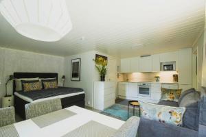 a living room with a bed and a kitchen at Airport Mint House Studio in Vantaa