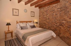 a bedroom with a bed with a brick wall at IRONWOOD LODGE in Pennington