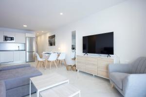 a living room with a couch and a tv at Lujosos Apartamentos Mónaco - Canary Good Vibes in Radazul