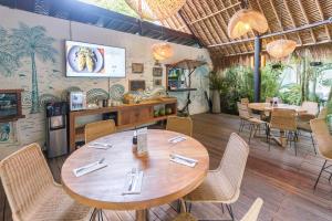 a restaurant with a large wooden table and chairs at The Green Room Seminyak in Seminyak