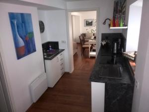 eine Küche mit einer schwarzen Arbeitsplatte und ein Wohnzimmer in der Unterkunft Altstadt Apartments in Querfurt