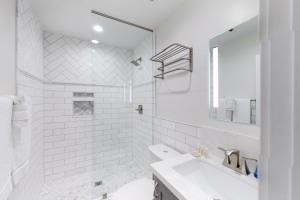 a white bathroom with a sink and a mirror at Historic Oldtown Plaza 201 in Scottsdale