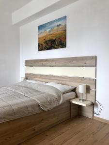 a bedroom with a bed and a painting on the wall at Vila Bellis in Tatranská Lomnica