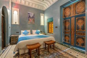a bedroom with a large bed with blue walls at Riad AZARO in Marrakesh