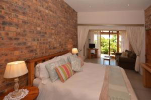 a bedroom with a brick wall and a bed at IRONWOOD LODGE in Pennington