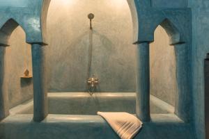 a bathroom with a bath tub with a towel in it at Riad AZARO in Marrakesh +60 photos