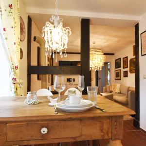a dining room with a table with a chandelier at Lavendelmond Ferien in Struchtrup +23 photos