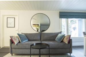 a living room with a couch and a round mirror at Airport Mint House Studio in Vantaa