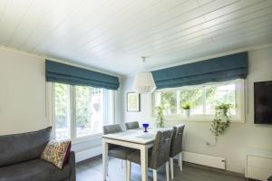 a dining room with a table and chairs and a couch at Airport Mint House Studio in Vantaa