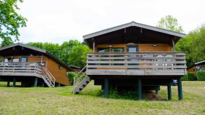 Cabaña de madera con una escalera que conduce a ella en Vallée Les Etoiles, en Blaimont