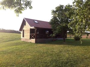 a small house in a field with a tree at Kauzeri - home while away from home in Vildoga
