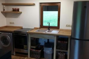a kitchen with a sink and a window at Kauzeri - home while away from home in Vildoga