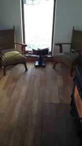 a living room with two chairs and a wooden floor at Kauzeri - home while away from home in Vildoga