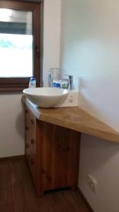 a bathroom counter with a sink and a window at Kauzeri - home while away from home in Vildoga +16 photos