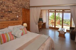 a bedroom with a bed and a brick wall at IRONWOOD LODGE in Pennington
