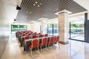 a conference room with long tables and red chairs at Barceló Murcia Siete Coronas in Murcia