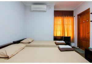 a bedroom with two beds and a window at Embe Enem Homestay in Yogyakarta